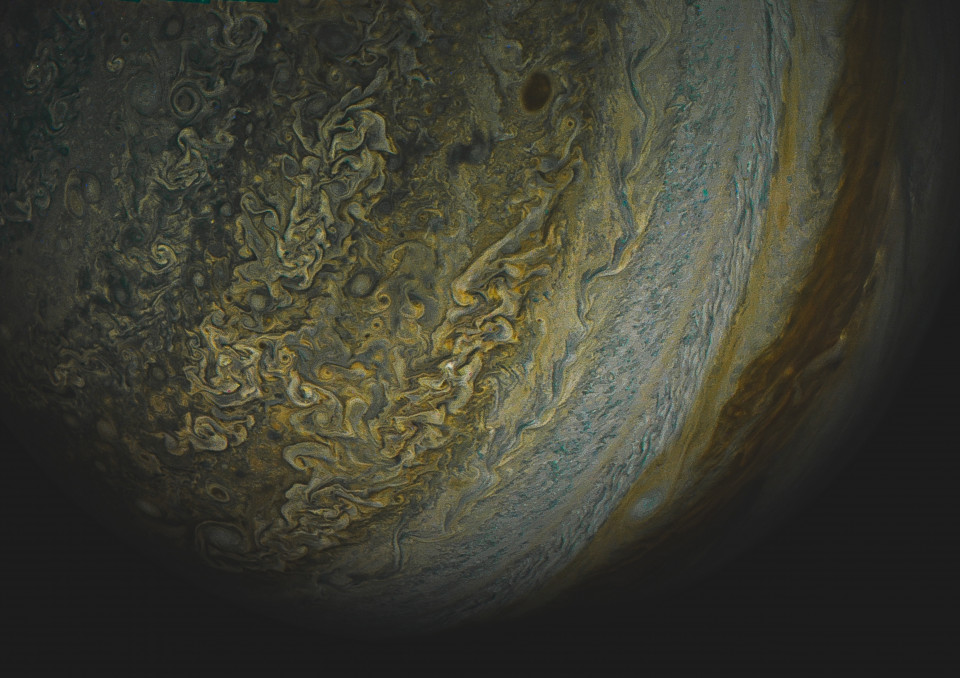 A dim JunoCam frame stretched hard, gold filaments against near-black cloud