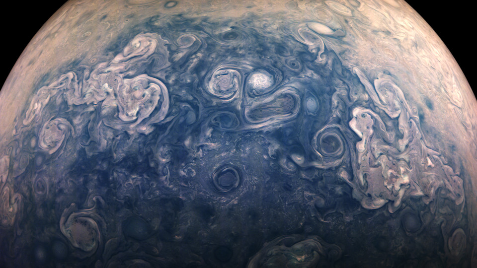 A field of white cyclones over deep blue cloud in Jupiter's polar region