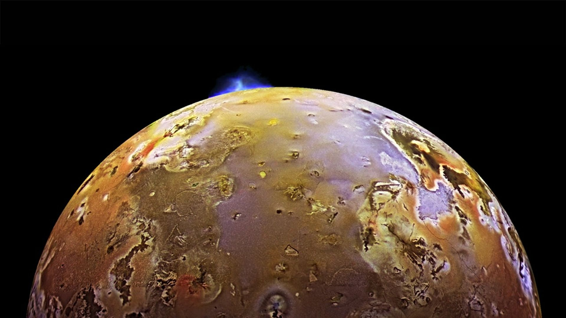 Io in mottled sulfur yellows with a blue volcanic plume rising above the limb