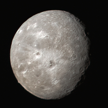 Oberon, a pale cratered globe with dark patches on several crater floors